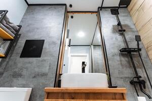 The bathroom features essential elements such as a sink, a reflective mirror, and a shower, creating a functional and stylish space for personal care and hygiene activities photo