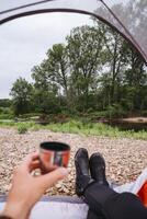Start your day with a peaceful camping morning by the riverside, sipping on a cup of coffee and enjoying the scenic view. Its a perfect way to relax and connect with nature photo
