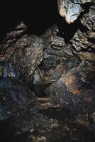 There is a cave that contains a significant number of rocks inside of it, creating an interesting and unique geological structure worth exploring further for its formations photo