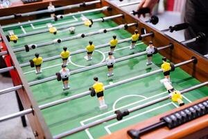 A person is actively engaged in playing a foosball game on a specially designed table meant for this exciting activity, showcasing skills and strategies in a friendly competition photo
