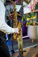 Saxophonist playing brass instrument in front of microphone photo