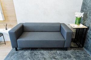 A Modern Minimalist Grey Sofa with a Side Table in a Contemporary Living Room is ideal for decoration, adding style, and enhancing the spaces aesthetic appeal photo
