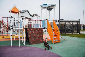 There is a vibrant playground that features not only a fun bike for kids to ride but also an exciting climbing wall for adventurous play. Its a perfect spot for leisure activities photo