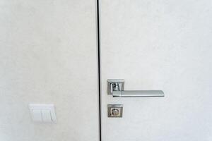 An intricate design and craftsmanship can be seen in the detailed image of a door handle on a white door, shown in a closeup view, emphasizing its elegance and structure photo