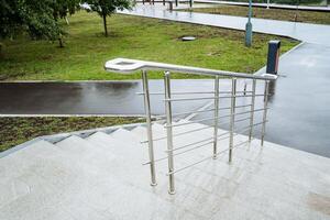 A modern staircase with stainless steel railing stands out against a rainy backdrop, creating a beautiful blend of modern design with the elements of nature on a gloomy day photo