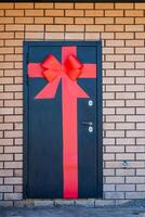 The charming red bow on the striking black door stands out against brickwork, creating a captivating feature in a balanced design. The door becomes a standout element in the setting photo