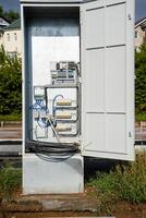 A Utility Box with an Open Door that Reveals its Internal Wiring and Associated Infrastructure Clearly Contrasting photo