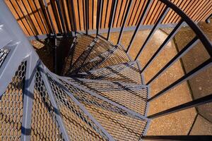 This stunning closeup of a spiral staircase features an exquisite metal railing, enhancing its aesthetic appeal and making it a remarkable visual delight from all angles photo