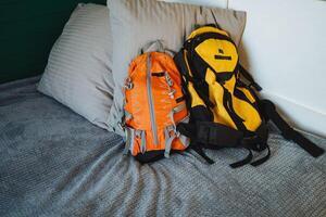 The bright yellow and orange backpack features a large t on its exterior, enhancing its distinctiveness and making it ideal for efficiently carrying personal belongings photo