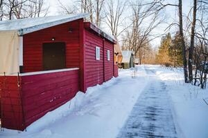 A snowy path leading to a red building photo