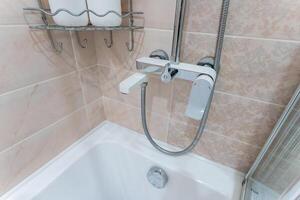 A bathtub with an attached shower head creates a versatile space photo