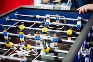 A person is enthusiastically involved in playing a competitive foosball game on a specially designed table that is specifically meant for this enjoyable and thrilling recreational activity photo