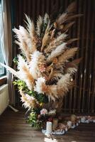 en un hermosamente decorado habitación, allí soportes un maravilloso Navidad árbol ese es únicamente hecho a mano desde pampa césped y adornado con varios vibrante flores, creando un festivo atmósfera foto