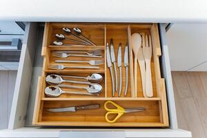 A wellorganized modern kitchen drawer filled with cutlery, utensils, and scissors, showcasing functional and neat arrangement of cooking tools and accessories photo
