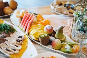 On the table, there is an assortment of colorful fruits and fresh vegetables arranged on various plates, creating a vibrant and appealing display of nutritious food options photo