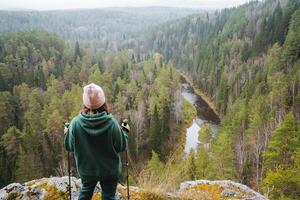 A breathtaking and stunning overlook of a serene, peaceful forested valley, where a hiker is joyfully enjoying the scenic view around them photo