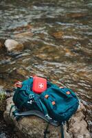 Be prepared for your outdoor adventure with this backpack featuring a first aid kit. Explore the wilderness near the stream with all the necessary gear for safety and health photo