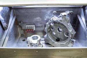 Inside a metal box, theres a separate piece of metal securely placed, indicating some type of mechanical or structural component. It could potentially be part of an automotive system photo
