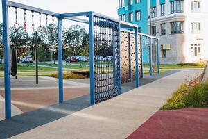 In the distance, there is a vibrant playground that features a blue building prominently in the background, making for a colorful scene filled with fun and community activities photo