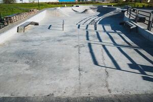 This impressive concrete skate park features unique shadows, making it an ideal spot for skate enthusiasts to demonstrate their exceptional skills in a lively and vibrant urban environment photo