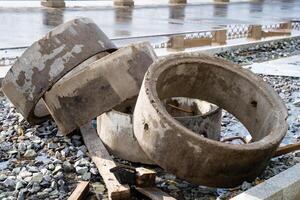 Three solid concrete rings are carefully stacked on top of one another, positioned securely on the ground surface, showcasing their sturdy construction and practical functionality photo
