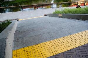 There is a distinct set of stairs featuring a prominent yellow stripe painted on the side for visibility and safety, designed to enhance the overall accessibility of the infrastructure photo