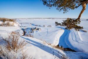 Frosty weather, view from the mountain of a tourist base in the forest, pine branch, spring morning. photo
