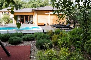 In a beautifully landscaped backyard, a sparkling and refreshing swimming pool serves as an ideal spot for relaxation and enjoyment during hot, sunny days filled with warmth and leisure photo