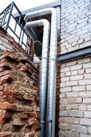 The structure features a sturdy brick wall with a securely attached metal pipe, showcasing a unique blend of materials that emphasize strength and practicality in modern construction photo