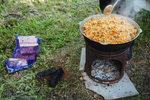 In a kitchen, a person is shown adding rice into a pot on a stove for cooking. This image showcases food preparation in a home environment, emphasizing the process of cooking photo