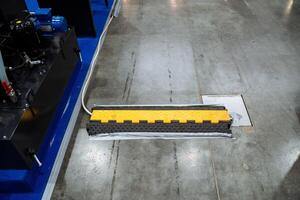 A shiny yellow and black rubber barrier is positioned on a concrete floor, enhancing safety and visibility in the area, making it an essential item in various building environments photo