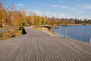 A serene wooden walkway gracefully leads to a tranquil lake, surrounded by lush trees in the background, providing a perfect view of natures natural beauty and calm water resources photo