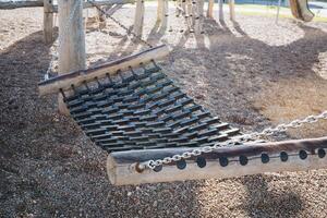 A comfortable hammock is carefully set up in the soft playground dirt, creating a unique and inviting space for relaxation and unwinding amidst the various fun outdoor activities available photo