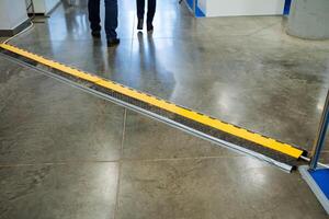 Two individuals are leisurely strolling down a long hallway that features a noticeable yellow stripe running along the floor, adding a vibrant touch to their surroundings photo