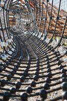This is a closeup view of a ropes course situated within a park, showcasing the intricate designs and connections of the ropes and structures used for climbing and navigating photo