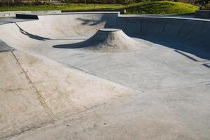An expansive, empty concrete skatepark bowl showcasing a variety of unique features specifically designed for the enjoyment of skaters photo