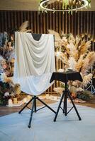 A solitary chair is placed gracefully in front of an elegantly covered table adorned with a pristine white cloth, creating a warm and inviting scene that everyone can appreciate and enjoy photo