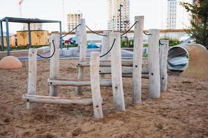 A beautifully crafted wooden playground featuring a set of stairs leading up to a fun slide, perfectly situated in a sandy area for children to enjoy their playtime activities photo
