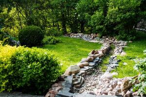 Take a leisurely stroll along the gardens meandering rocky trail, surrounded by abundant foliage, to immerse yourself in the serene allure of nature and its calm environment photo