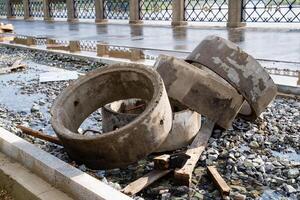 Abandoned and neglected concrete rings along with debris found throughout an urban setting or environment photo