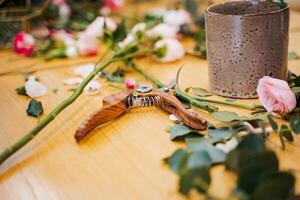 Pair of scissors on wooden table with flower vase for event garnish photo