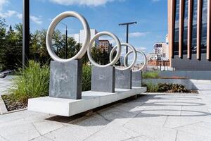 An abstract and aesthetic modern art installation featuring circular metal sculptures in a contemporary urban setting, creatively blending art and architecture photo