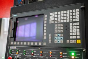 This is a detailed closeup view of a sophisticated machine control panel that features various buttons and a digital screen, showcasing its advanced functionalities and technology photo