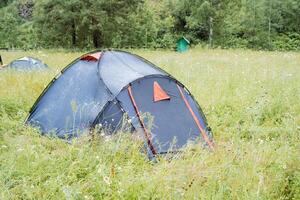 Set in a grassy meadow, a tent provides a peaceful setting to unwind and connect with the natural surroundings. This tranquil scene encourages outdoor leisure and serenity photo