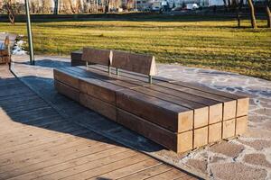 In the serene setting of a park, there sits a beautifully crafted wooden bench, with a lush grassy field stretching out in the background, creating a picturesque scene for relaxation photo
