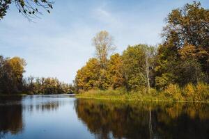 On a beautiful sunny day, a picturesque lake is encircled by lush green trees, creating a serene and tranquil natural landscape just waiting to be explored, a haven of peace photo
