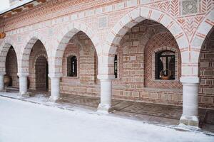 Snowcovered brick building featuring arches and columns photo
