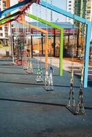 There is a vibrant row of colorful swings located in a beautifully designed park, inviting children and families to enjoy outdoor leisure and recreation activities together photo