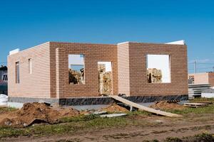 Construction of a residential building, with brick walls and numerous windows, is in progress at a construction site, showcasing ongoing development in creating the structure photo
