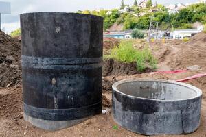 A bustling construction site featuring large concrete pipes with an expansive urban background visible nearby photo